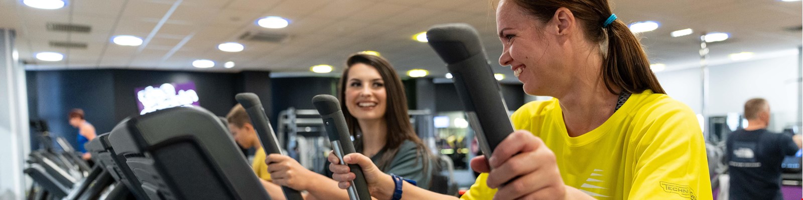 two women using the equipment in the gym